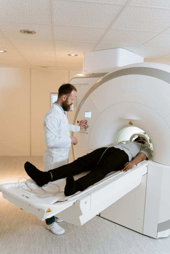 Doctor operating MRI scanner for patient examination in a hospital setting.